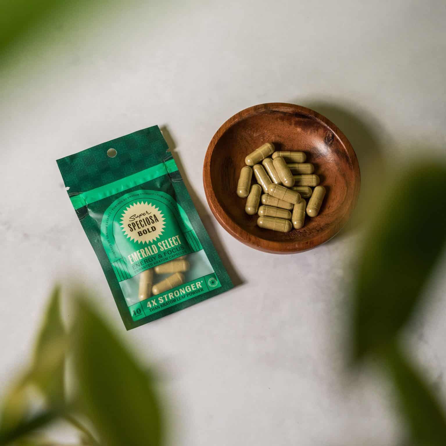 bowl of emerald select enhanced enhanced kratom capsules with bag