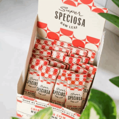 Super Speciosa's Cherry Bomb Calm Red Maeng Da Flavored Kratom Powder Sticks in box with green plant.